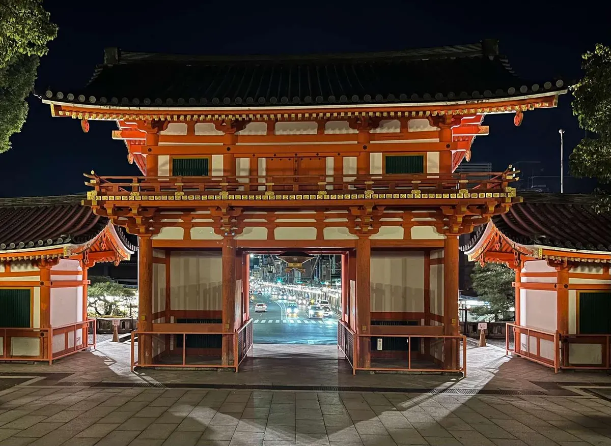 The illuminated vermilion gate of Yasaka Shrine at night beside Kyoto's Gion geisha district