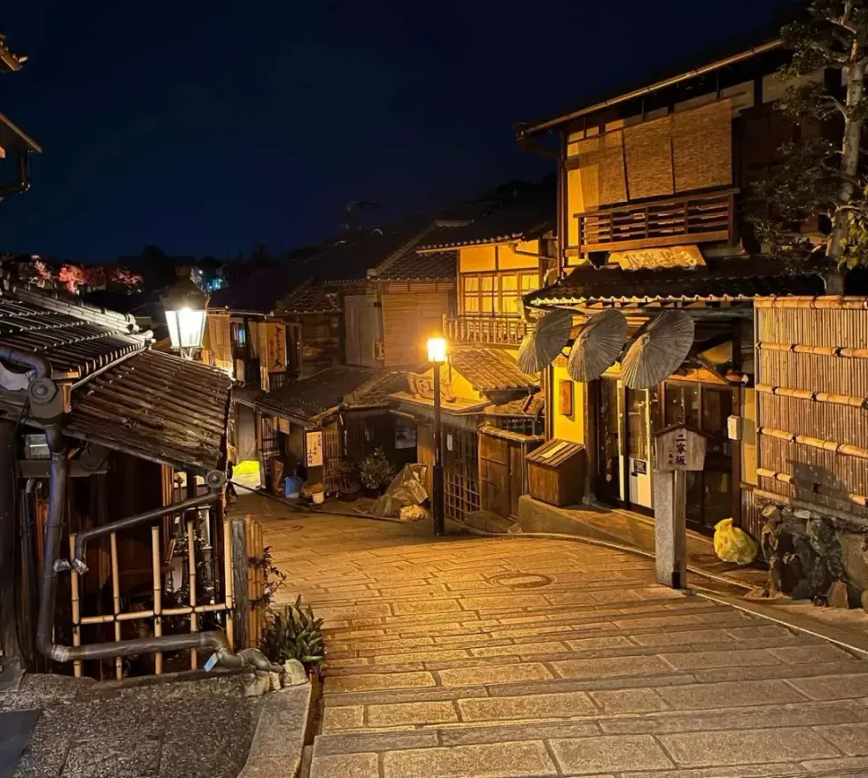 Lantern-lit historic stone street near Kyoto's Gion geisha district at night on an after-dark walking tour