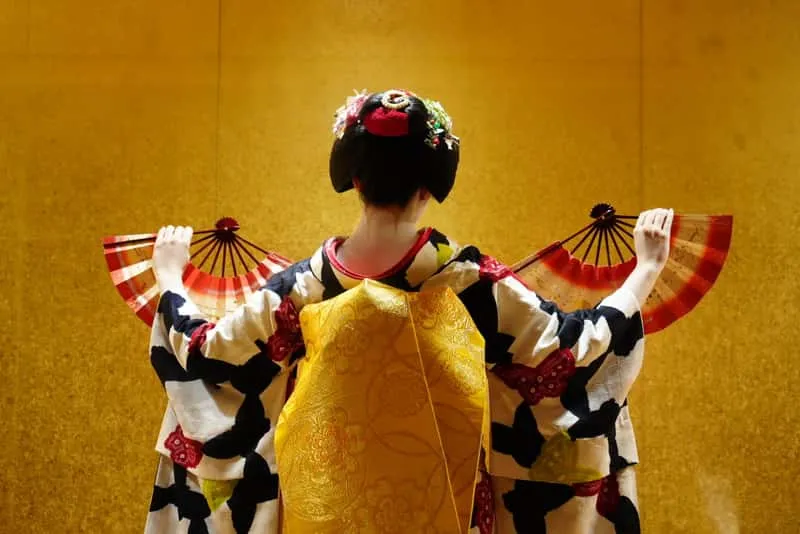 Geiko performing a fan dance during a one-hour geisha show in Kyoto with guests watching, Japan