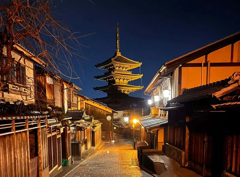 Guide and small group on an after-dark walking tour of Kyoto's Gion geisha district with glowing teahouse lanterns, Japan
